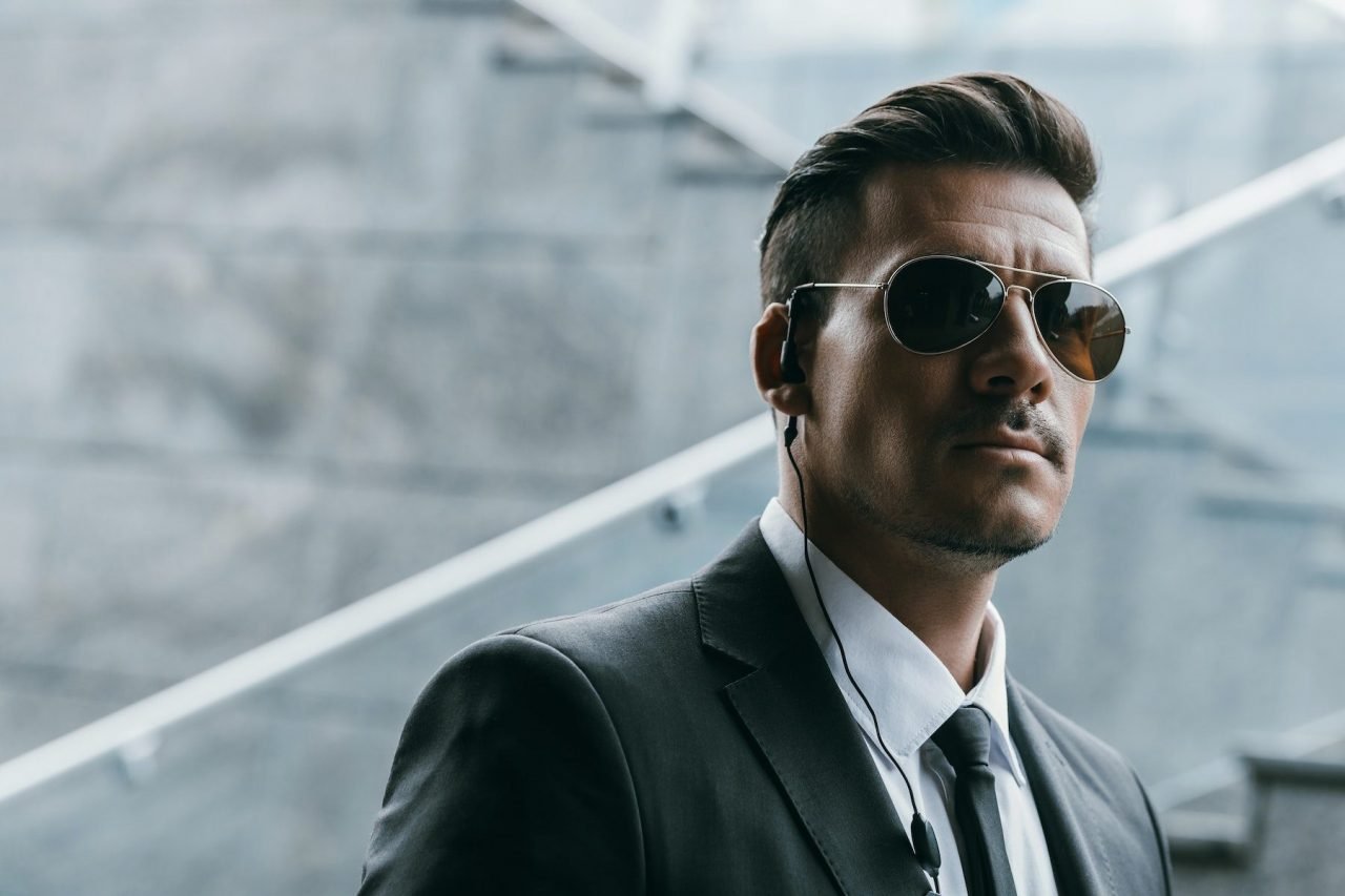 Security guard in sunglasses with an earpiece on duty