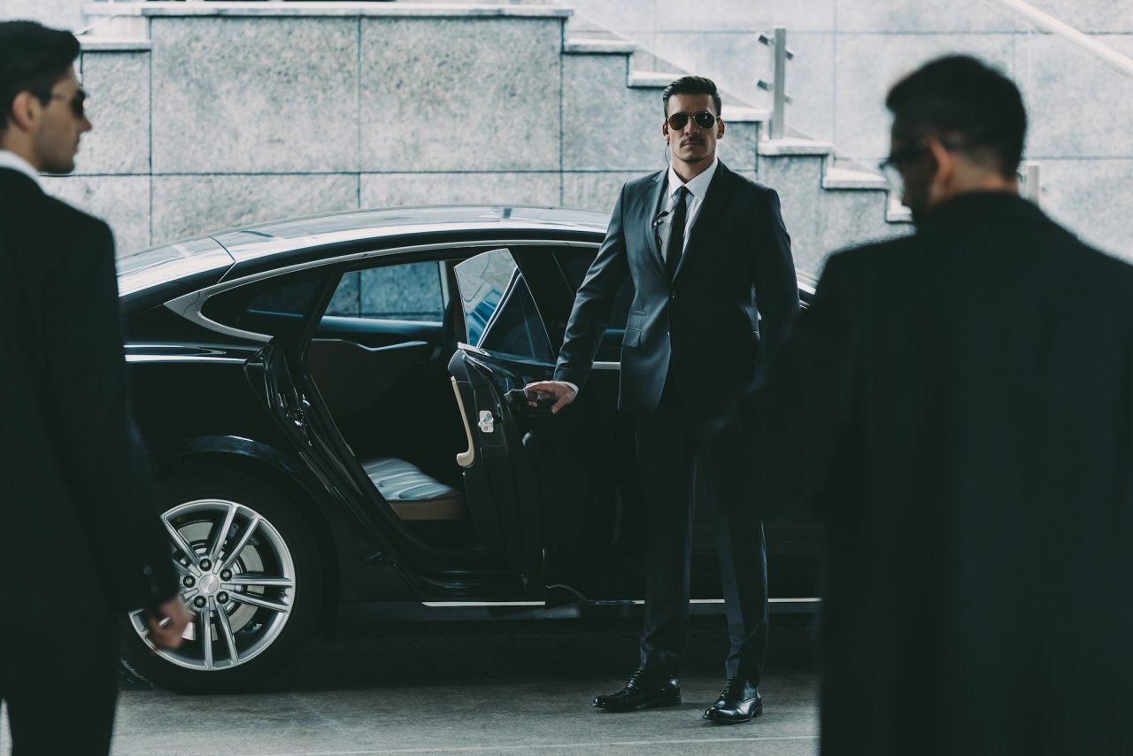 Security officer escorting a guest from a vehicle at an event venue